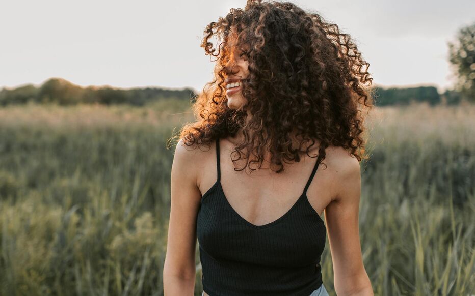 Femme aux cheveux bouclés se promène dans la nature
