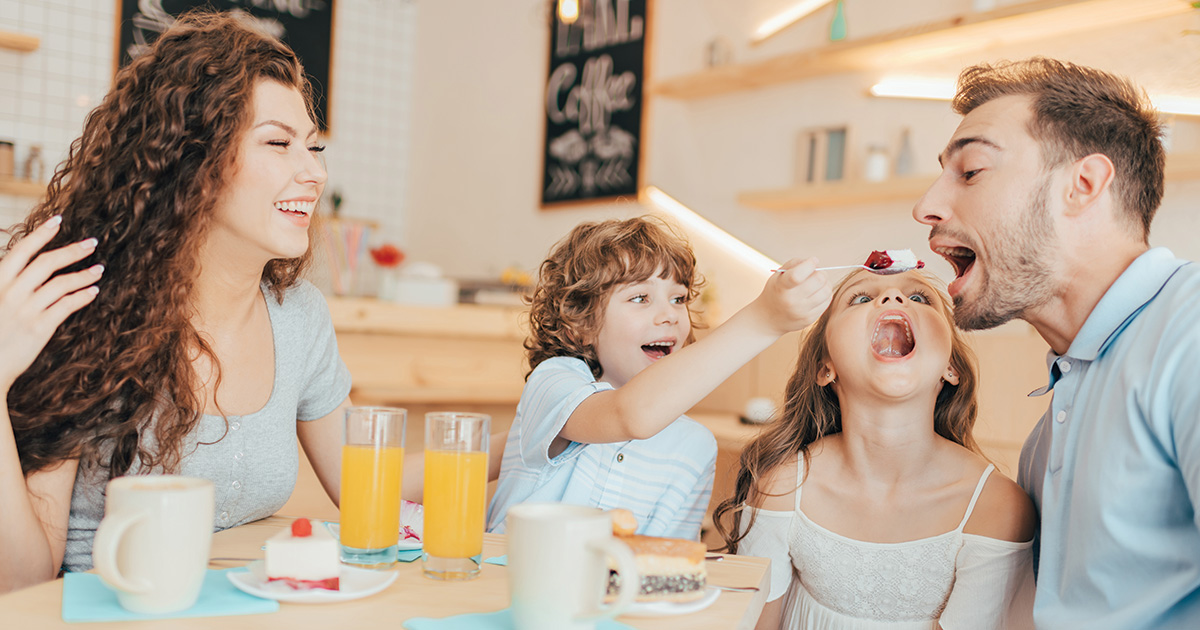 un couple partageant un repas avec deux enfants, un garçon et une fille,